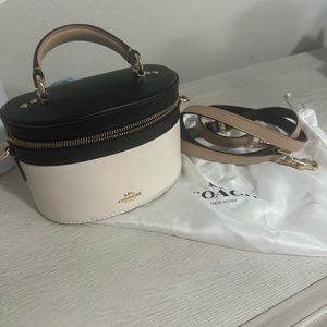 Coach Selena Trail Bag in cream and black with gold hardware.